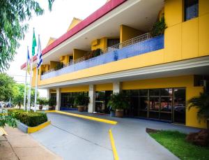 a yellow building with a balcony on top of it at Pousada dos Girassóis in Palmas