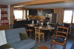 eine Küche und ein Esszimmer mit einem Tisch und Stühlen in der Unterkunft Résidence LE BEC DE L AIGLE - N°15 in Laveissière