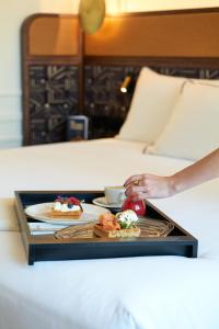 a tray with two plates of food on a bed at Only YOU Hotel Valencia in Valencia