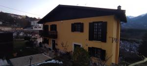 un edificio amarillo con techo negro y ventanas en Villa Ola, en Barrea