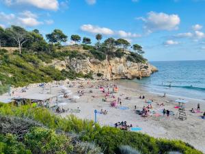 un grupo de personas en una playa cerca del océano en Cap Salou Apolo, en Salou