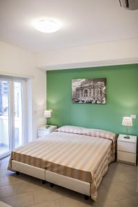 ein Schlafzimmer mit einem großen Bett und einer grünen Wand in der Unterkunft Vatican Rooms Holiday in Rome in Rom