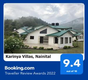 una imagen de una casa blanca con techos verdes en Karinya Villas en Nainital