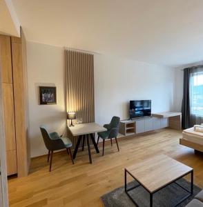 a living room with a table and chairs and a tv at Apartmani G8 in Pale