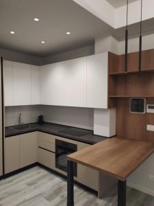 a kitchen with white cabinets and a wooden table at Helvetia Garibaldi in Genoa +17 photos