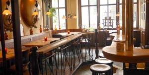 比克堡的住宿－巴克貝格步奧豪斯酒店，餐厅内带木桌和凳子的酒吧