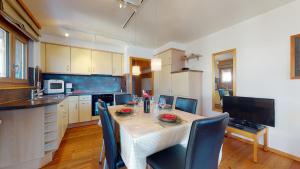 cocina con mesa y sillas en Greppons COSY & MOUNTAIN apartments by Alpvision Résidences, en Veysonnaz