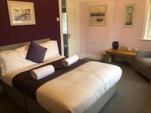 una camera con un letto con due cuscini sopra di The George Inn Middle Wallop a Stockbridge