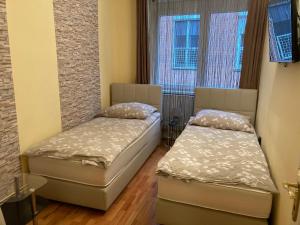 two beds in a room with two windows at Szent János Vendégház in Eger