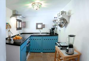 una cocina con armarios azules y una batidora sobre una mesa en Casa Escondida en Albuñuelas