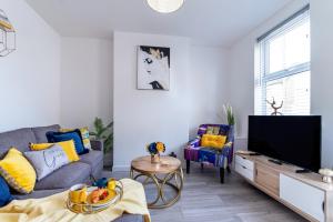 a living room with a couch and a tv at KVM - Star House in Peterborough