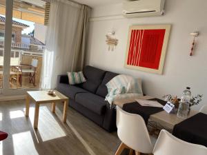 Una sala de estar con un sofá azul y una mesa. en Sol Apartment, en L'Estartit