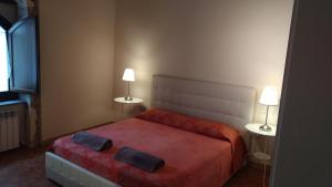 1 dormitorio con 1 cama roja y 2 lámparas. en Il Borghetto Medievale suite, en Fabriano