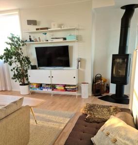 ein Wohnzimmer mit einem TV und einem Kamin in der Unterkunft Lyxig vindsvåning nära Kalmar slott och havet in Kalmar