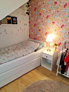 Lyxig vindsvåning nära Kalmar slott och havet في كالمار: غرفة نوم مع سرير مع زهور على الحائط