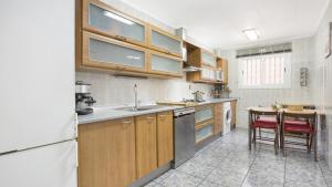 a kitchen with wooden cabinets and a table in it at 2Vil01 - Lloret de Mar in Lloret de Mar