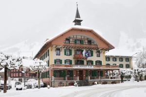 een groot gebouw met een dak in de sneeuw bij FLÜHLI Hotel Kurhaus in Flühli