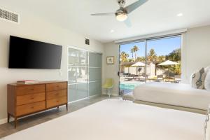 a bedroom with a large bed and a tv at Modern Palms in Palm Springs +46 photos