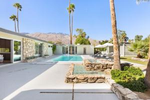 a house with a swimming pool and palm trees at Modern Palms in Palm Springs