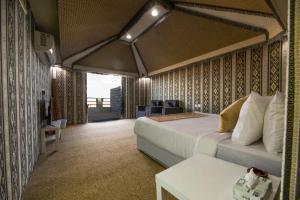 a hotel room with a bed and a desk at منتجع قرية الفقرة in As Sudayrah