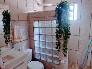 a bathroom with a toilet and plants on the wall at Suits - Canto do sabia in Brotas