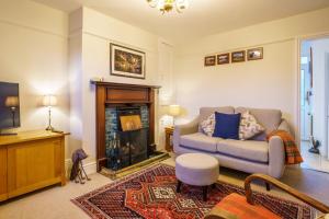 a living room with a couch and a fireplace at Otter View in Kendal