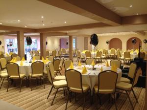 una habitación llena de mesas y sillas con servilletas amarillas en The Royal Hotel, en Mundesley