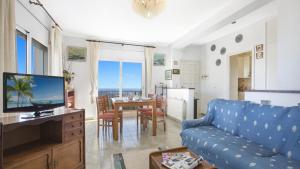 un salon avec un canapé bleu et une salle à manger dans l'établissement 2Tere - Lloret de Mar, à Puigventos