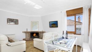 a living room with white furniture and a fireplace at Villa Tensi in Blanes