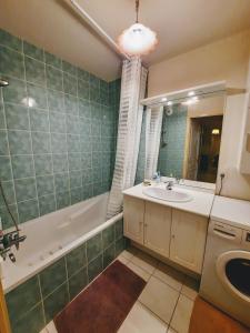 a bathroom with a sink and a tub and a mirror at Entre Lac d'Annecy et montagnes, golf et parapente à pieds in Talloires