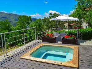 a hot tub on a deck with a table and chairs at Agriturismo Vezzano in Chiusi della Verna