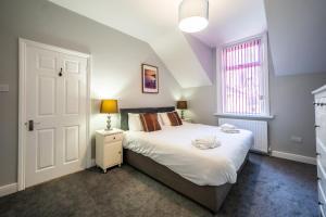 1 dormitorio con cama blanca y ventana en Eden Vale - City Centre By Horizon Stays en Sunderland