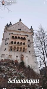 un grande edificio bianco in cima a una collina di Haus bei der Linden Ferienwohnungen a Schwangau