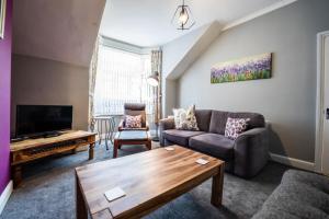 a living room with a couch and a tv at Eden Vale - City Centre By Horizon Stays in Sunderland