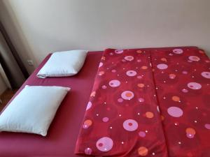 a red bed with polka dot sheets and pillows at Žvėryno appartment-Self check-in-Free garage in Vilnius