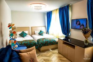 a hotel room with two beds and a flat screen tv at AVE MEDICA Apartments in Palanga