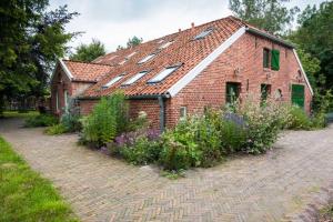 a brick house with windows and flowers in front of it at Doppelzimmer Holthusen 25515 in Weener