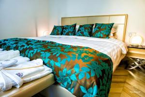 1 dormitorio con 1 cama con manta verde y almohadas en AVE MEDICA Apartments en Palanga