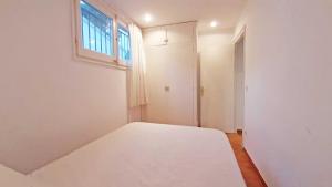 a white room with a bed and a window at 1 Sire - Llafranc in Calella de Palafrugell