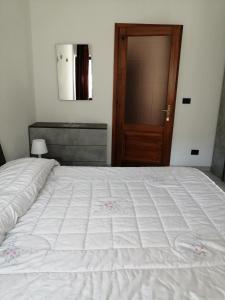 una camera da letto con un grande letto bianco e una porta in legno di appartamento due - CIR 0007 ad Aosta