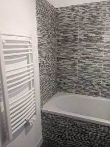 a bathroom with a shower with a toilet and a tub at Appartement 200m de l'océan avec piscine extérieure in Mimizan