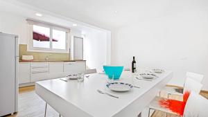 a white dining room with a white table and chairs at 1 Sica - Llafranc in Llafranc