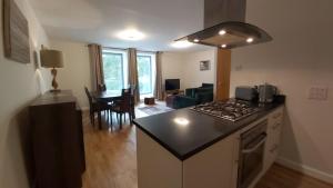 a kitchen and living room with a stove top oven at Highland Club Scotland Apartments in Fort Augustus
