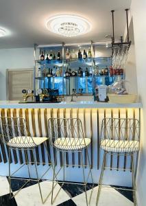 a bar with three bar stools in a kitchen at AVE MEDICA Apartments & SPA in Palanga