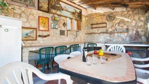 uma mesa e cadeiras numa cozinha com uma parede de pedra em 2Alo - Lloret de Mar em Mont Barbat