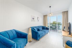 sala de estar con sofá azul y TV en Ustronie Apartments z widokiem na morze 20 m do plaży, en Ustronie Morskie