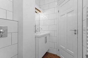 uma casa de banho branca com um lavatório e um espelho em Berg Apartments em Reykjavík
