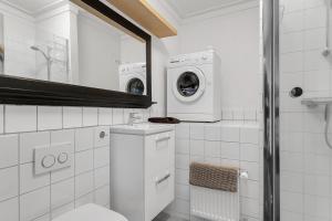uma casa de banho com um WC e uma máquina de lavar roupa em Berg Apartments em Reykjavík