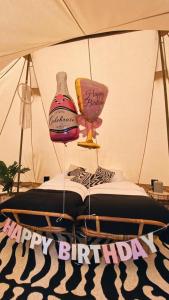 une lampe et un vase sur un lit avec un signe d'anniversaire heureux dans l'établissement ASILI DELUXE - Zebra, à Lichtaert