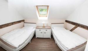 two beds in a room with a table and a window at Ferienwohnung 2 Holthusen 25516 in Weener